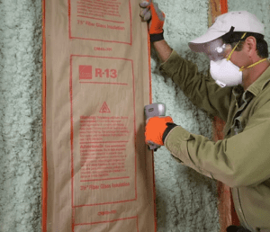 tradesman installing insulation in home